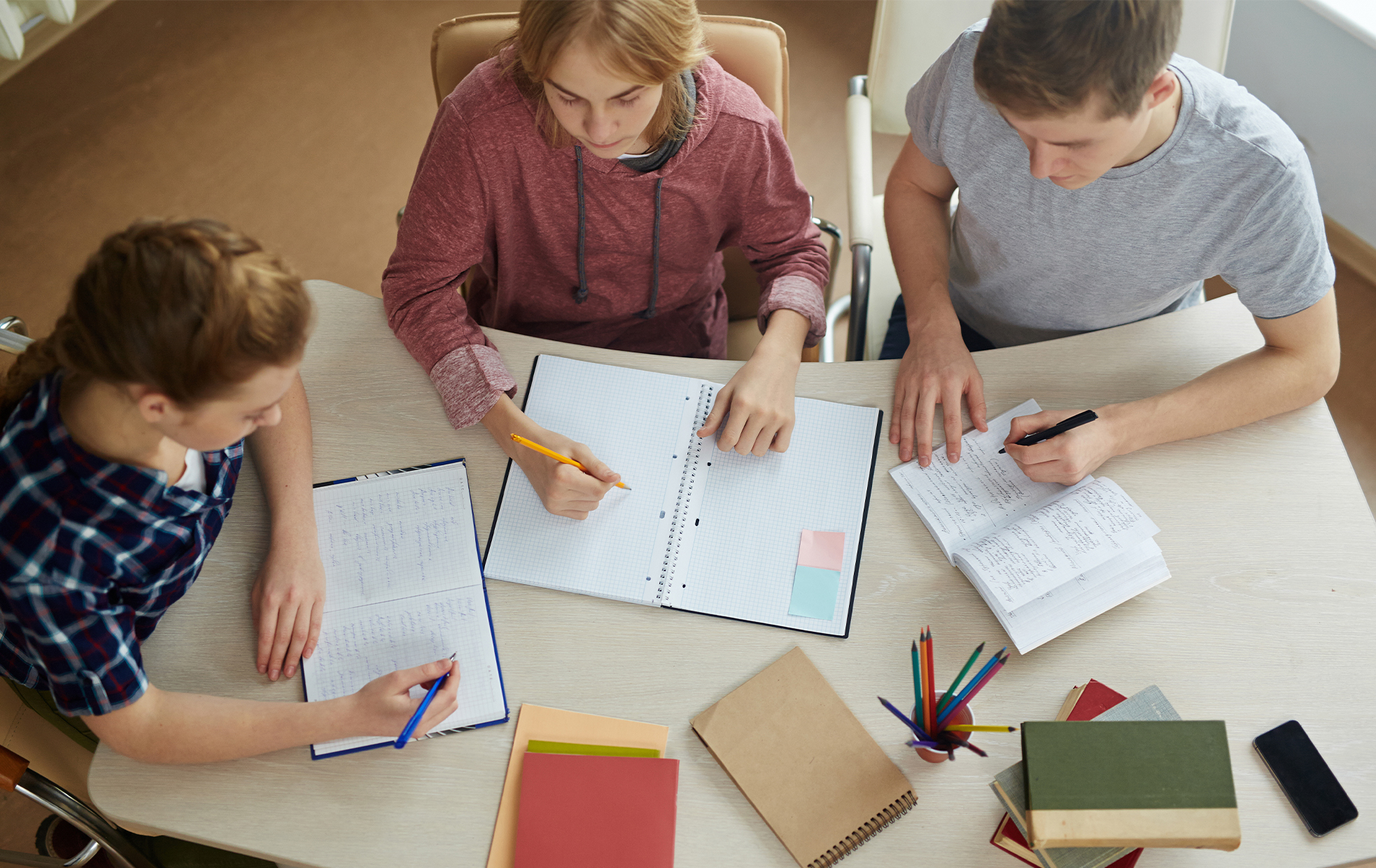 students sitting at a table studying seen from above