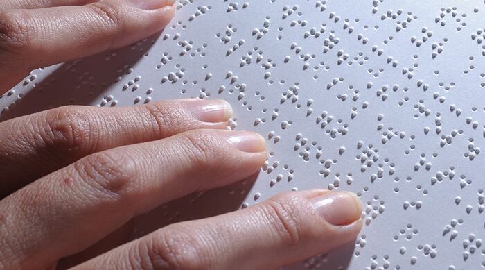 Immagine di mani che leggono il braille