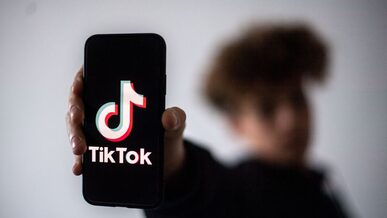 Persona oscurata che tiene in mano un cellulare con l'app di tik tok