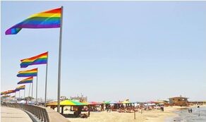 Spiaggia con ombrelloni e bandiere rainbow