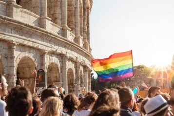 Gruppo di persone che innalza una bandiera rainbow