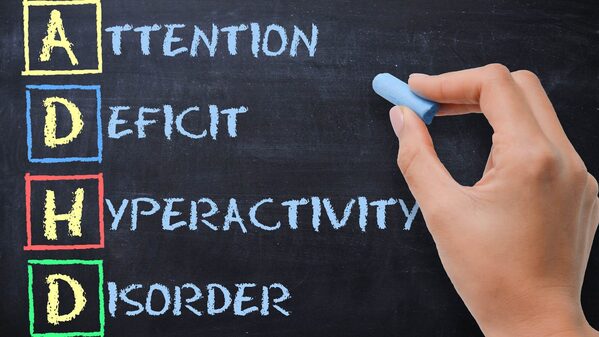 Lavagna con mano che scrive: Attention Deficit Hyperactivity Disorder