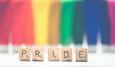 Scritta Pride con sfondo arcobaleno